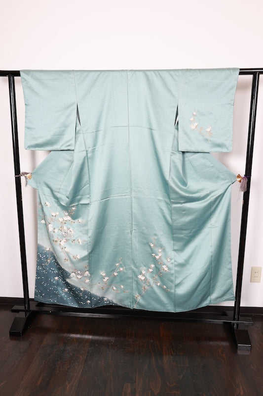 New, unused formal kimono (houmongi) in light blue, gold, brown, green, and white, with a continuous woven pattern of tachibana (mandarin orange) and children's motifs. (R90)