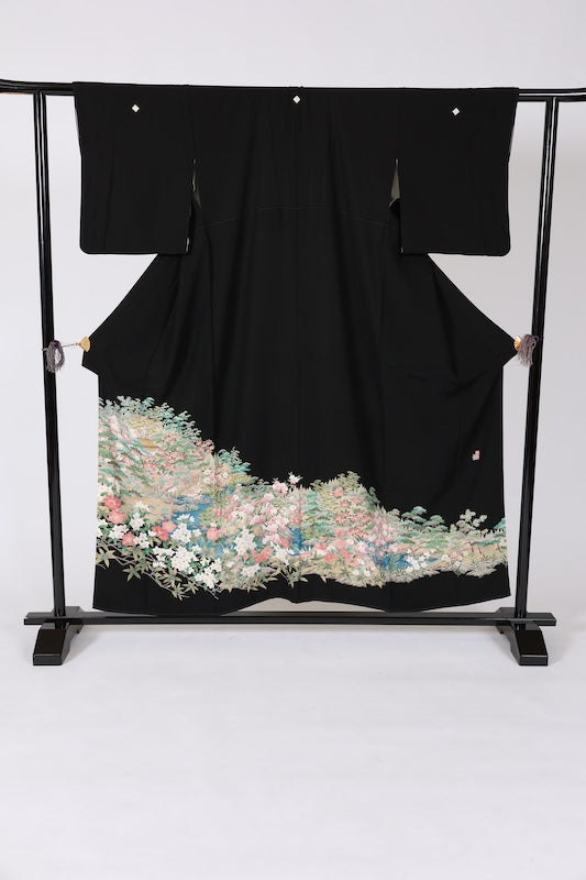 Black formal kimono used (Kurotomesode) with five crests and a four-diamond pattern. Colors: green, indigo, cherry blossom pink, gray, beige. Features a traditional landscape design. Kyoto Yuzen dyeing technique. J8