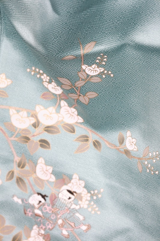 New, unused formal kimono (houmongi) in light blue, gold, brown, green, and white, with a continuous woven pattern of tachibana (mandarin orange) and children's motifs. (R90)