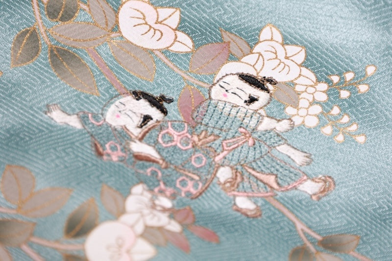 New, unused formal kimono (houmongi) in light blue, gold, brown, green, and white, with a continuous woven pattern of tachibana (mandarin orange) and children's motifs. (R90)