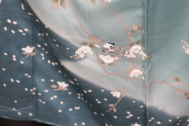 New, unused formal kimono (houmongi) in light blue, gold, brown, green, and white, with a continuous woven pattern of tachibana (mandarin orange) and children's motifs. (R90)