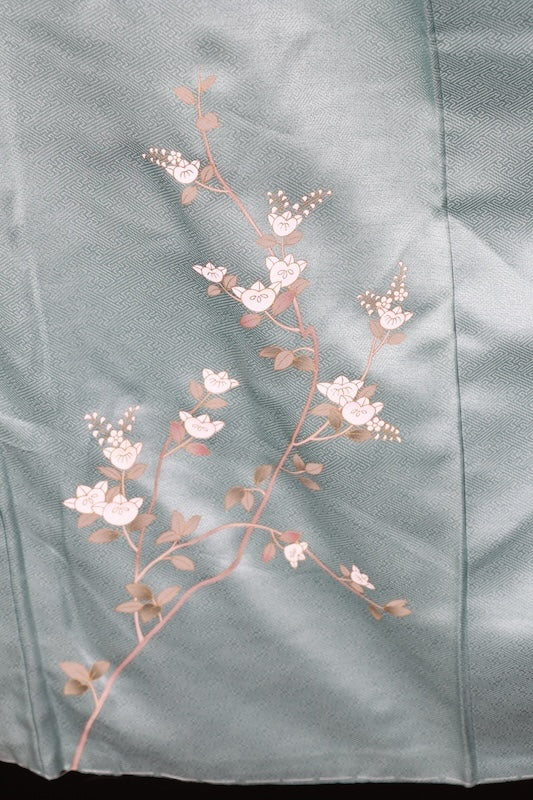 New, unused formal kimono (houmongi) in light blue, gold, brown, green, and white, with a continuous woven pattern of tachibana (mandarin orange) and children's motifs. (R90)