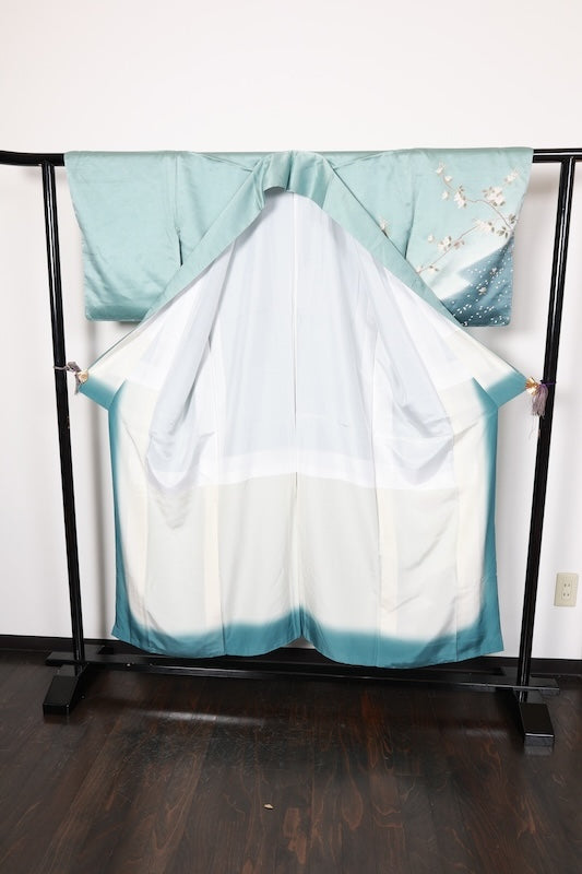 New, unused formal kimono (houmongi) in light blue, gold, brown, green, and white, with a continuous woven pattern of tachibana (mandarin orange) and children's motifs. (R90)