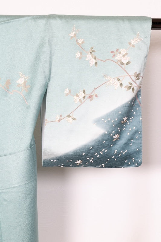 New, unused formal kimono (houmongi) in light blue, gold, brown, green, and white, with a continuous woven pattern of tachibana (mandarin orange) and children's motifs. (R90)
