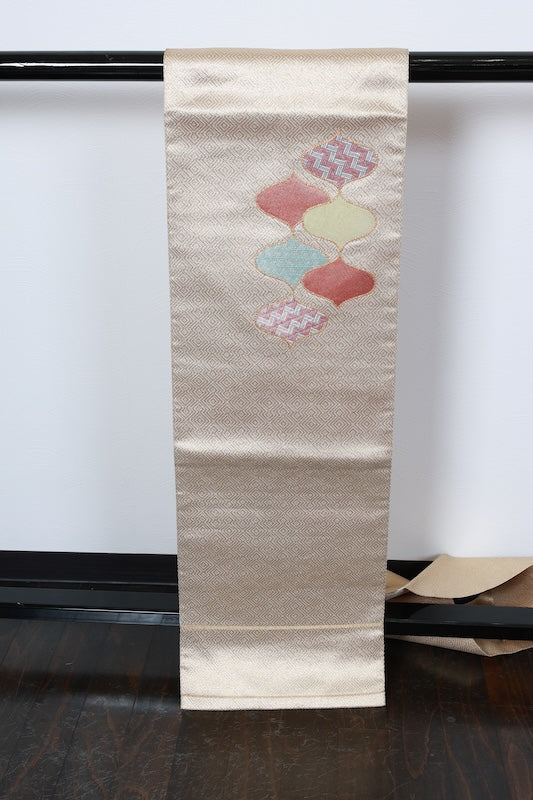 Nagoya obi (used sash) by Masuya Takao, gold, blue, light green, coral, rising wave pattern, pine needle diamond pattern, brocade weave, R225