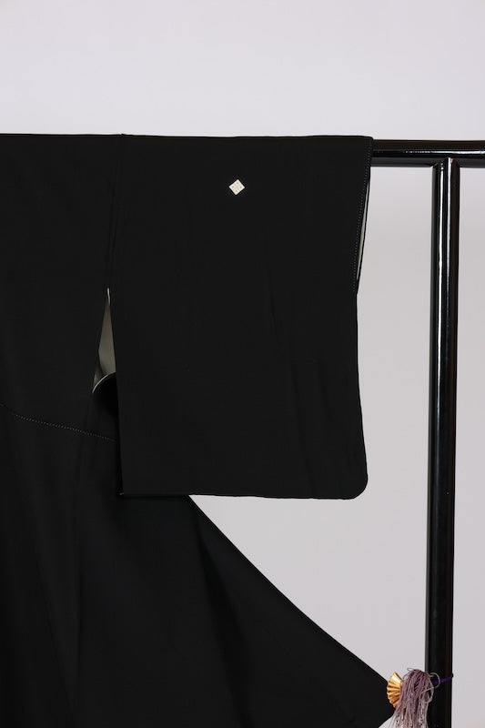 Black formal kimono used (Kurotomesode) with five crests and a four-diamond pattern. Colors: green, indigo, cherry blossom pink, gray, beige. Features a traditional landscape design. Kyoto Yuzen dyeing technique. J8