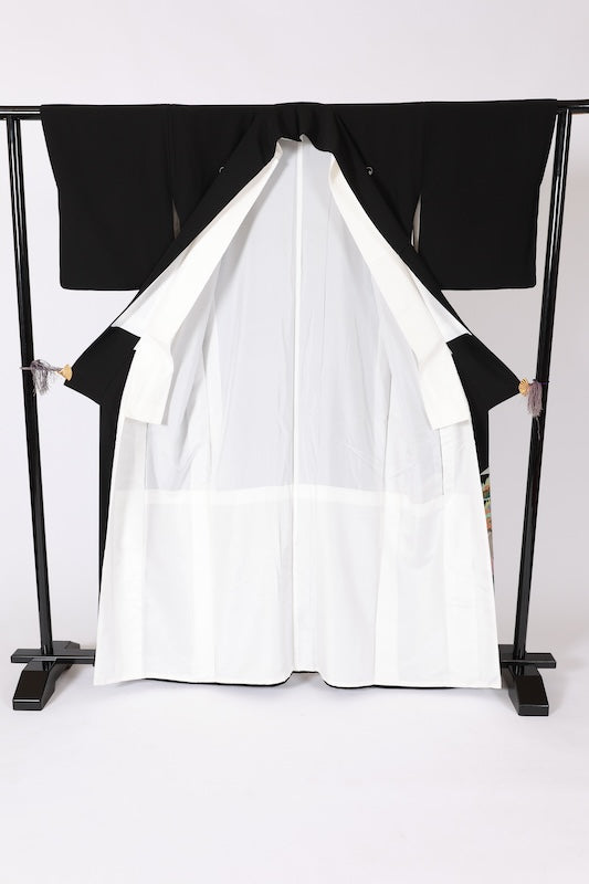 Black formal kimono used(Kurotomesode) with five crests of overlapping arrows in a circle, in shades of yellow-green, purple, indigo, coral, and white, depicting a seaside landscape, by a renowned artist, Kyoto Kaga Yuzen dyeing technique, L47