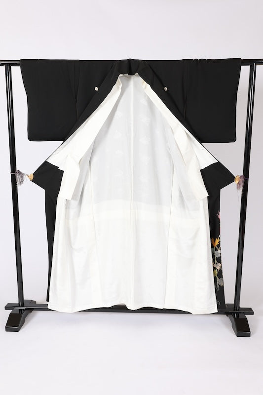 Black formal kimono used (Kurotomesode) with plum blossom design, gold, gray, ochre, coral, shades of green, gold thread embroidery, bamboo fence, and flowers. Artist-made. L46