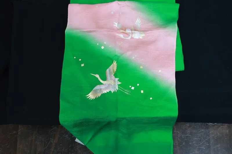 used Stole: Cherry-blossom pink, green, gold, and silver; featuring a crane motif and an all-over woven pattern (R348).