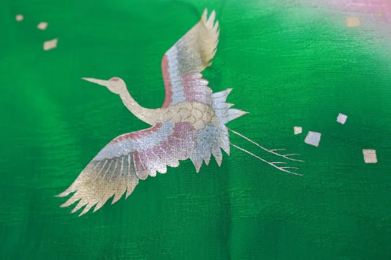used Stole: Cherry-blossom pink, green, gold, and silver; featuring a crane motif and an all-over woven pattern (R348).