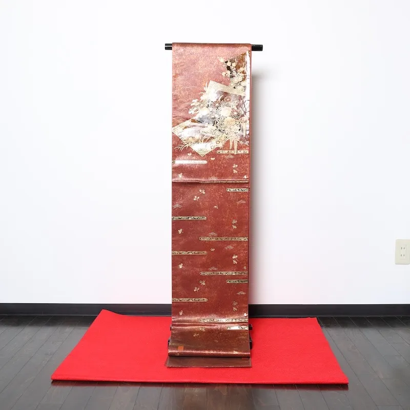 Fukuro obi　used (formal sash), lacquer and gold leaf, plum blossoms, chrysanthemums, cherry blossoms, seigaiha (wave pattern), flower cart, rust-red, tataki (stamped) finish, taiko (drum-shaped) pattern, P