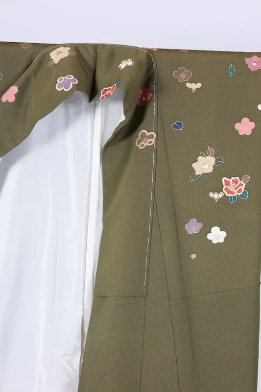 New, unused formal kimono (houmongi) in green, purple, white, red, blue, and gold, featuring camellia and cherry blossom patterns. (G10)