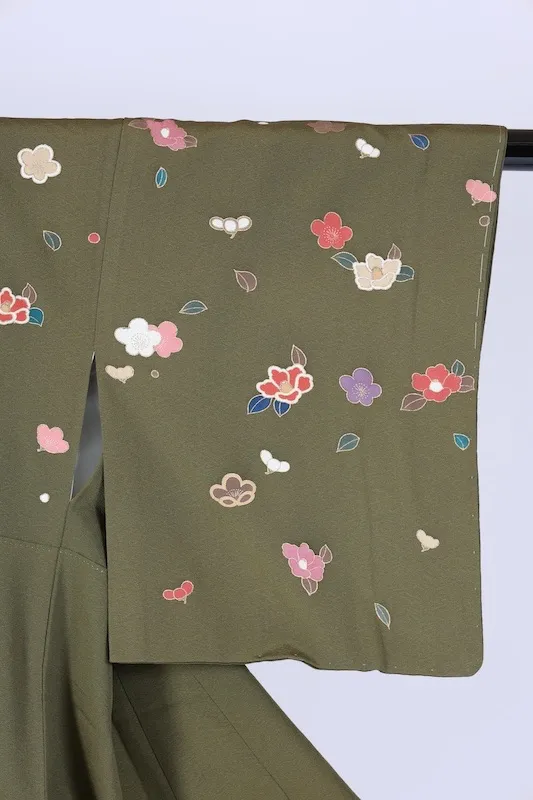 New, unused formal kimono (houmongi) in green, purple, white, red, blue, and gold, featuring camellia and cherry blossom patterns. (G10)
