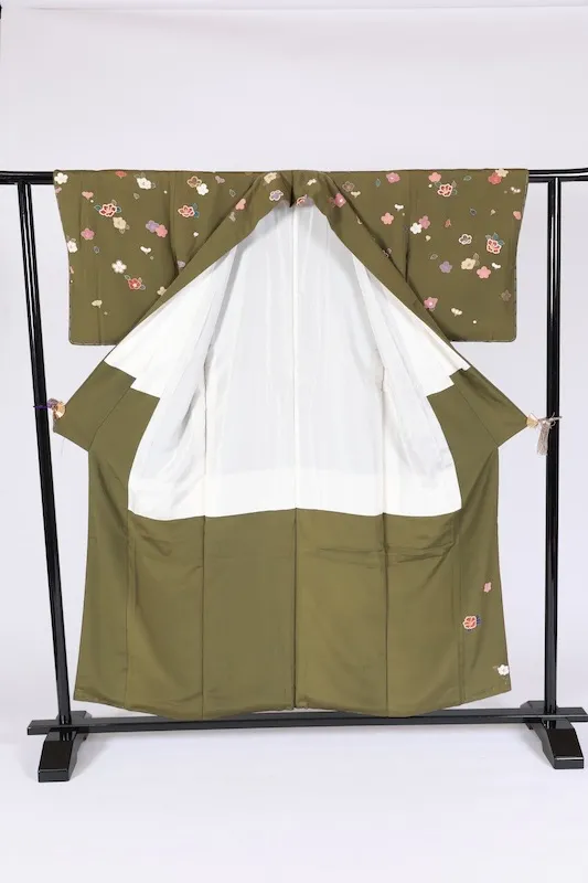 New, unused formal kimono (houmongi) in green, purple, white, red, blue, and gold, featuring camellia and cherry blossom patterns. (G10)