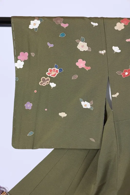 New, unused formal kimono (houmongi) in green, purple, white, red, blue, and gold, featuring camellia and cherry blossom patterns. (G10)